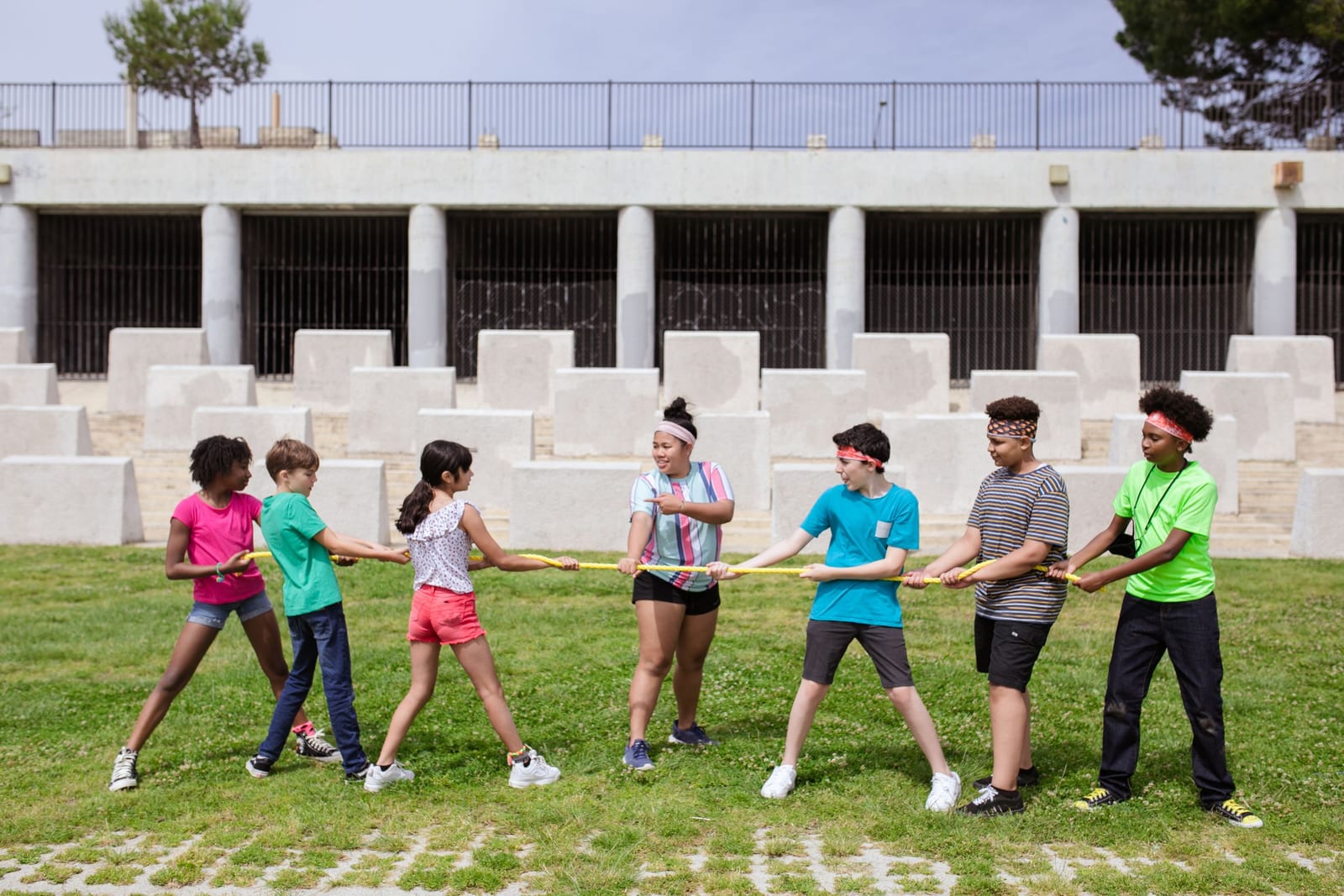 A team of children playing tug-of-war on the grass