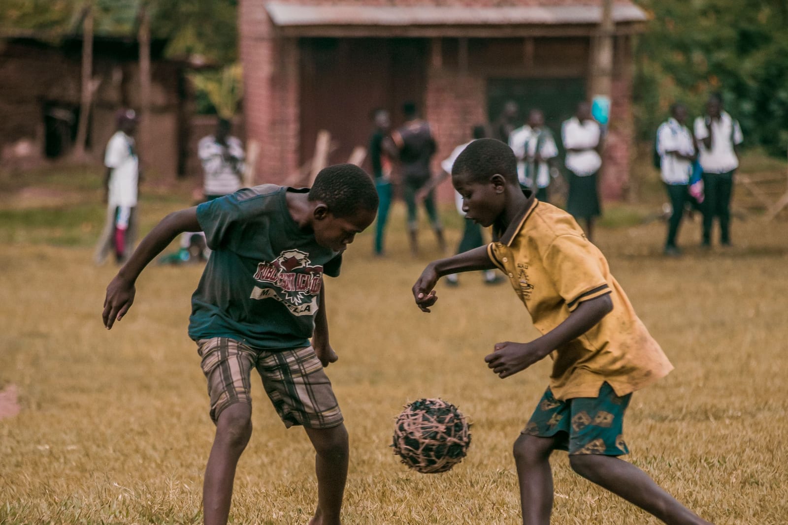 Two boys playing soccer on an open field